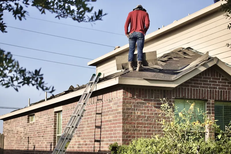 Professional roofer working on a residential roof in Stratham